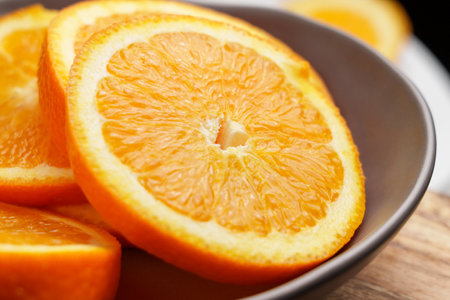 Sliced juicy orange in kitchen bowl as a source of vitamin Cの写真素材