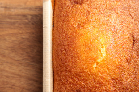 Close-up of fresh Spanish lemon sponge cake in paper mold. Fluffy crumb and golden crust. Homemade...