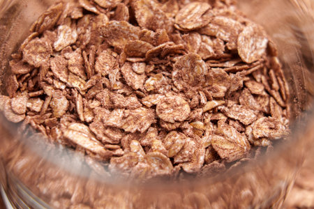 Dry oat flakes with organic cocoa powder in a glass container. Macro shot.の写真素材