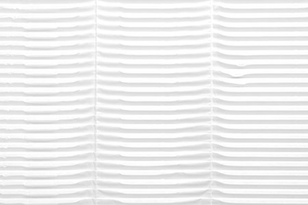 Rows of white corrugated ribbed cardboard. Abstract background. Embossed textured paper of packaging...