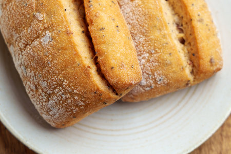 Freshly toasted fluffy wheat buns on a kitchen plate. Cracked bread. Top view.