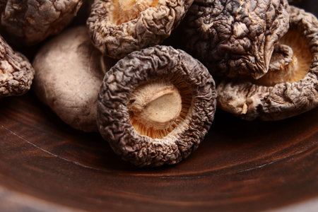Raw dehydrated shiitake mushrooms in wooden rustic bowl. Dried foodsの写真素材