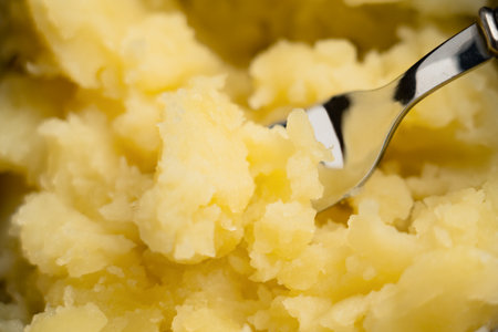Steel fork in hot freshly mashed boiled potatoes. Healthy organic food. Macro shotの写真素材