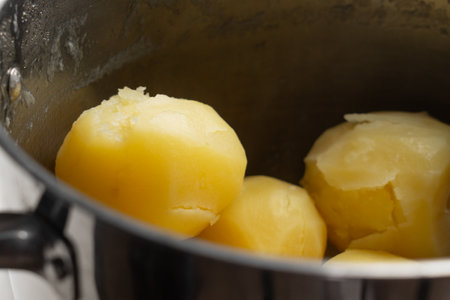 Whole peeled boiled potatoes in steel saucepan close upの写真素材