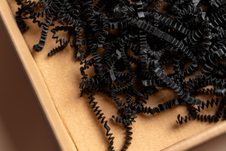 Postal cardboard box with shredded black paper filler close upの写真素材