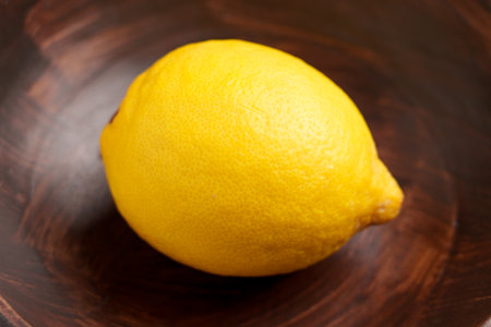 Whole citrus fruit lemon in a wooden bowl close upの写真素材