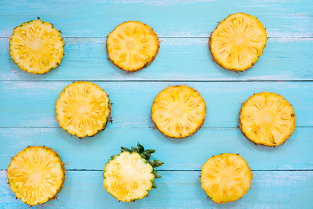 Tropical pineapple slices on wood plank blue color. summer fruit background conceptの写真素材