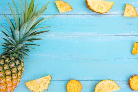 Tropical pineapple on wood plank blue color. frame layout summer vacation background concept.の写真素材