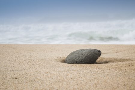 single stone in sand on the beachの写真素材