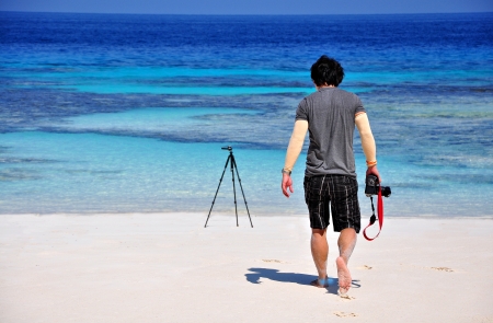 A man with digital camera and tripod on beautyfuly beach  Concept about ready for landscape photographyの写真素材