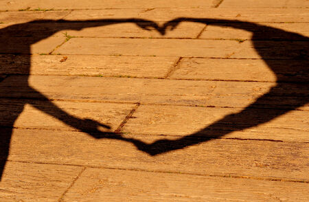 Silhouette of hands making sign heart on wood background  Concept about love and relationshipの写真素材