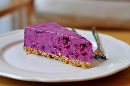 Fresh slice of blueberry cheesecake on white plateの写真素材