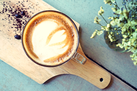 Hot coffee on wood background (Hot Latte in vintage style)の写真素材