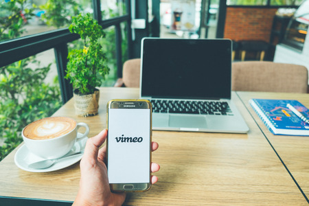 CHIANG MAI, THAILAND - June 26,2018: A Man holds Samsung Galaxy S7 edge Mobile Phone with Vimeo...