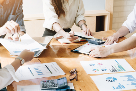 Professional investor and financial meeting present time. Young business team working with new startup project in office room present marketing strategies plan and Calculate revenueの写真素材