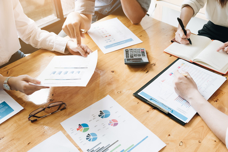 Business team meeting discussing working analysis with financial data and marketing growth report graph in workspaceの写真素材
