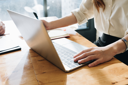 Female working with laptop and notebook woman's hands on notebook computerの写真素材