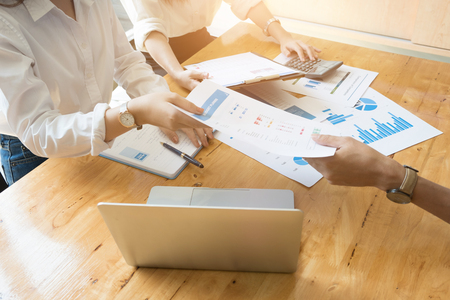 Business team meeting discussing working analysis with financial data and marketing growth report graph in workspaceの写真素材