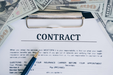 One hundred dollar bill and contract with pen in the middle, Mortgage and Home Loan concept.の写真素材