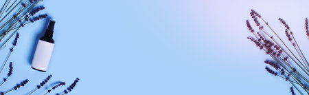 Glass spray bottle on a blue background surrounded by lavender. Web banner.の写真素材