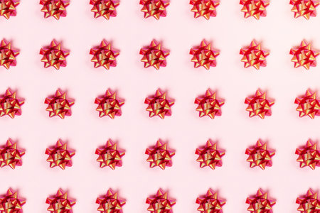 Christmas and new year pattern. Celebration picture. Pink background with red bright bows. Flat lay, top view.の写真素材