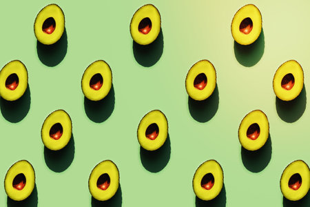 Half of avocados in sunlight on a green neon background.の写真素材