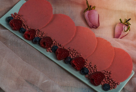 pink wafers with raspberries and blueberries and roses background