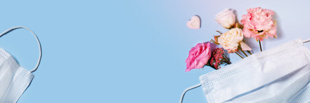 A medical mask with a bouquet of flowers inside. Keep your distance - be healthy and happy. A holiday card with a medical bias.の写真素材
