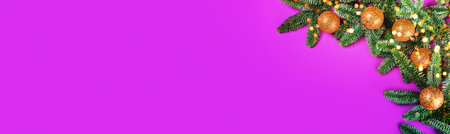 Christmas banner with fir brunches, golden balls and lights on purple background. Flat lay, top view, copy space.の写真素材