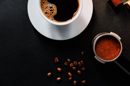 Delicious expresso in white cup on black table with beans.の写真素材