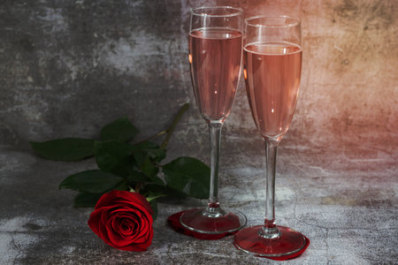 two glasses of champagne and a rose on a white background and copy space valentine's day symbolの写真素材