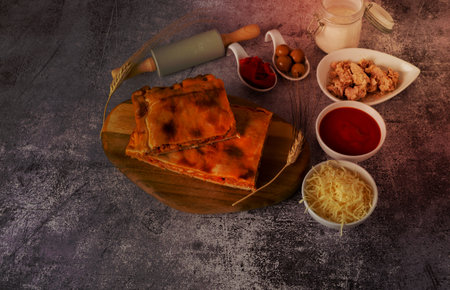 tuna empanada with all the ingredients separated in ceramic containers in the bottom of a red brick wallの写真素材