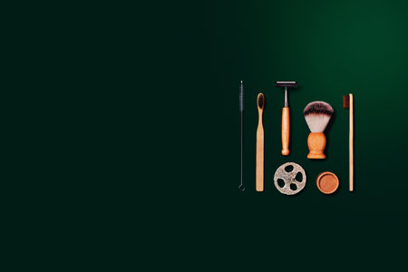Zero waste concept. Natural bamboo toothbrush, razor, paper tube, natural sponge on green background. Flat lay, top view, copy space.の写真素材