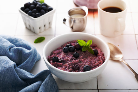 Blueberry oatmeal for breakfast ith coffee on white tableの写真素材