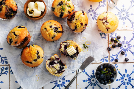 Blueberry muffins with fresh berries and blueberry preserves served with butterの写真素材