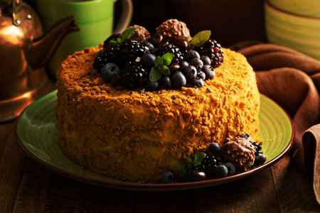 A piece of honey layered cake with crumb topping and fresh berries