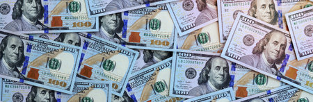 A large number of US dollar bills of a new design with a blue stripe in the middle. Top view.