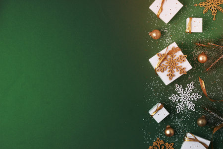Christmas decorations with packaging gifts and Christmas tree on green background. Flat lay, copy spaceの写真素材