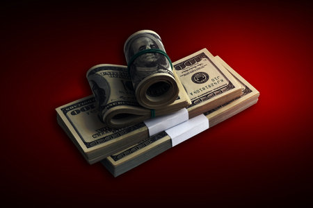 Bundle of US dollar bills on crimson red background. Pack of american money with high resolution on dark red background with dark vignetteの写真素材