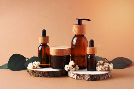 Cosmetic skin care products with eucalyptus and wood on brown background. Close upの写真素材