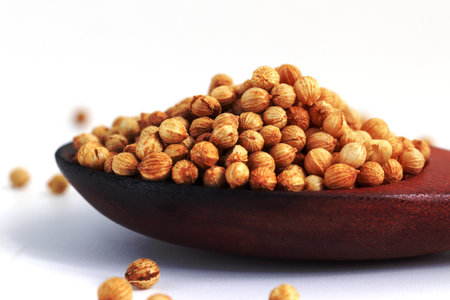 close up Coriander seeds in a wooden spoon on white backgroundの写真素材