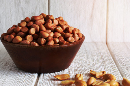peanuts in a wood bowl on background