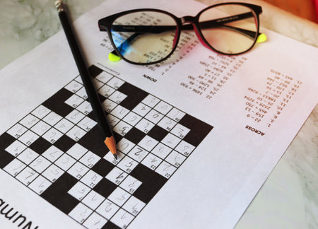 Pencil and glasses on the paper with solved number crossword puzzleの写真素材