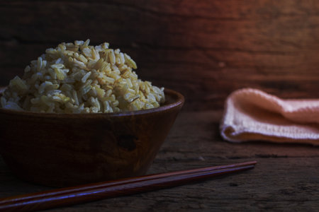 Organic Brown Rice in the bowl on the wooden tableの写真素材