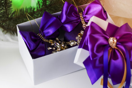 A Christmas gift decorated with a beautiful bow on a light background with a fir twig. Gifts, joy, surprise. Selective focus. the concept of Christmas and New Year. background for the banner.の写真素材