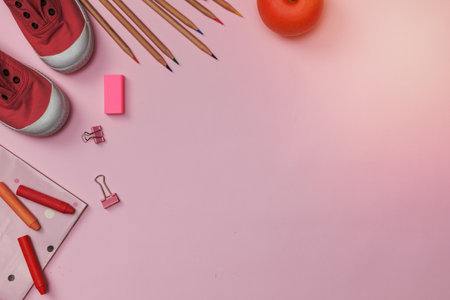 Creative flatlay of education pink table with student books, shoes, colorful crayon, empty space isolated on pink background, Concept of education and back to schoolの写真素材