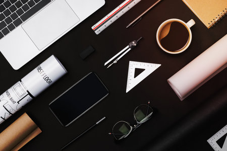 Creative flat lay of architects black table with roll blueprints, architectural project plan, engineering tools, office supplies, laptop computer and a cup of hot coffee,Workspace for designer conceptの写真素材