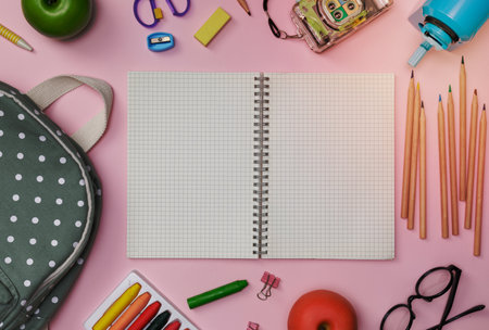 Creative flatlay of education pink table with backpack, student books, shoes, colorful crayon, eye glasses, empty space isolated on pink background, Concept of education and back to schoolの写真素材