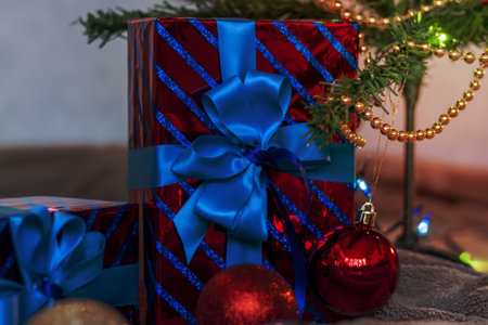 Holiday gifts with blue bows under the tree. Christmas and New year. The concept of an advertising banner.の写真素材