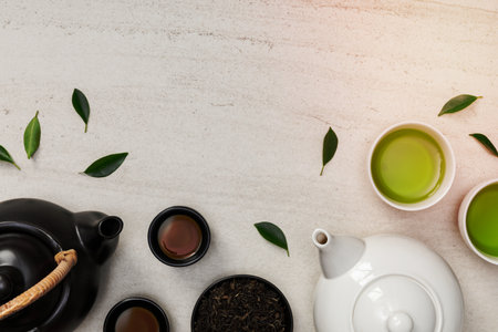 Cup of hot tea with teapot, green tea leaves and dried herbs top view on the white stone table empty space, Organic product from the nature for healthy with traditional styleの写真素材